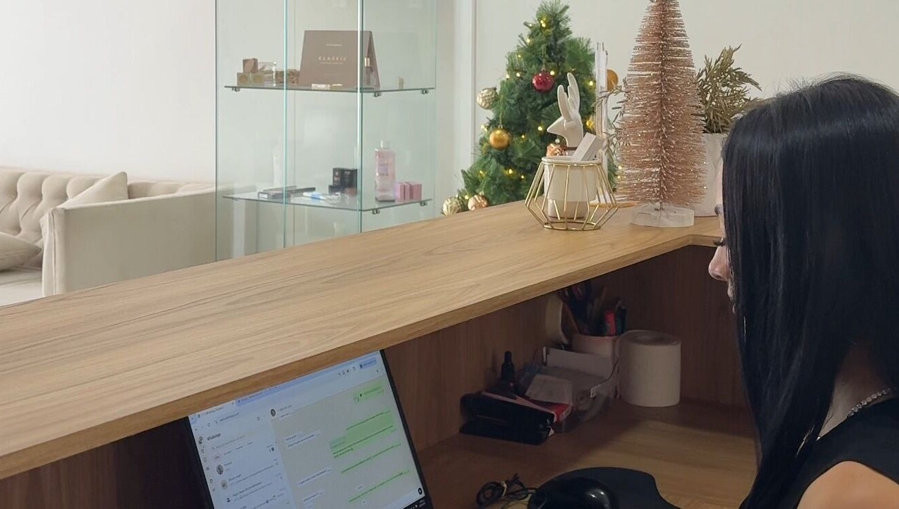 Reception at AnglikBrowsStudio in Cundinamarca with festive decor and a staff member at the desk.
