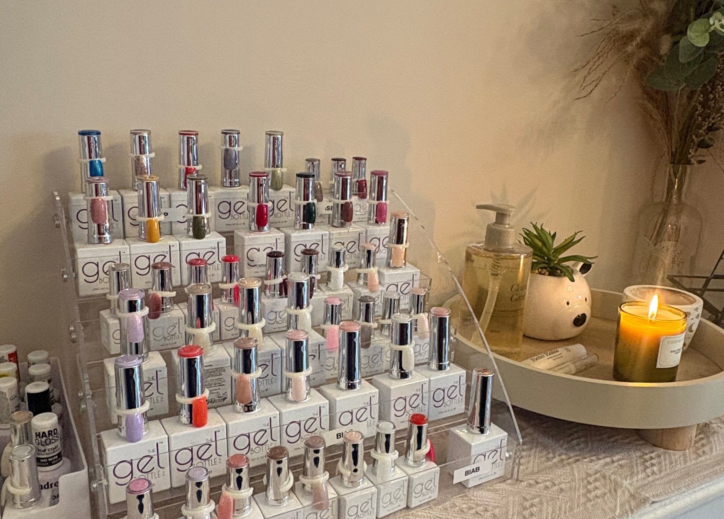 Nail polish display at Nails by Dena in Blackpool, England, GB. Cozy ambiance with candles and greenery.