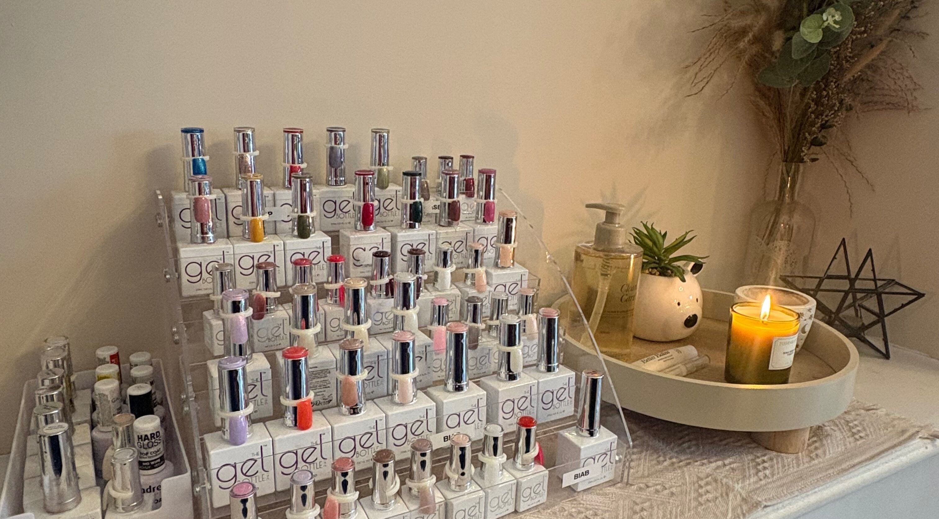 Nail polish display at Nails by Dena in Blackpool, England, GB. Cozy ambiance with candles and greenery.