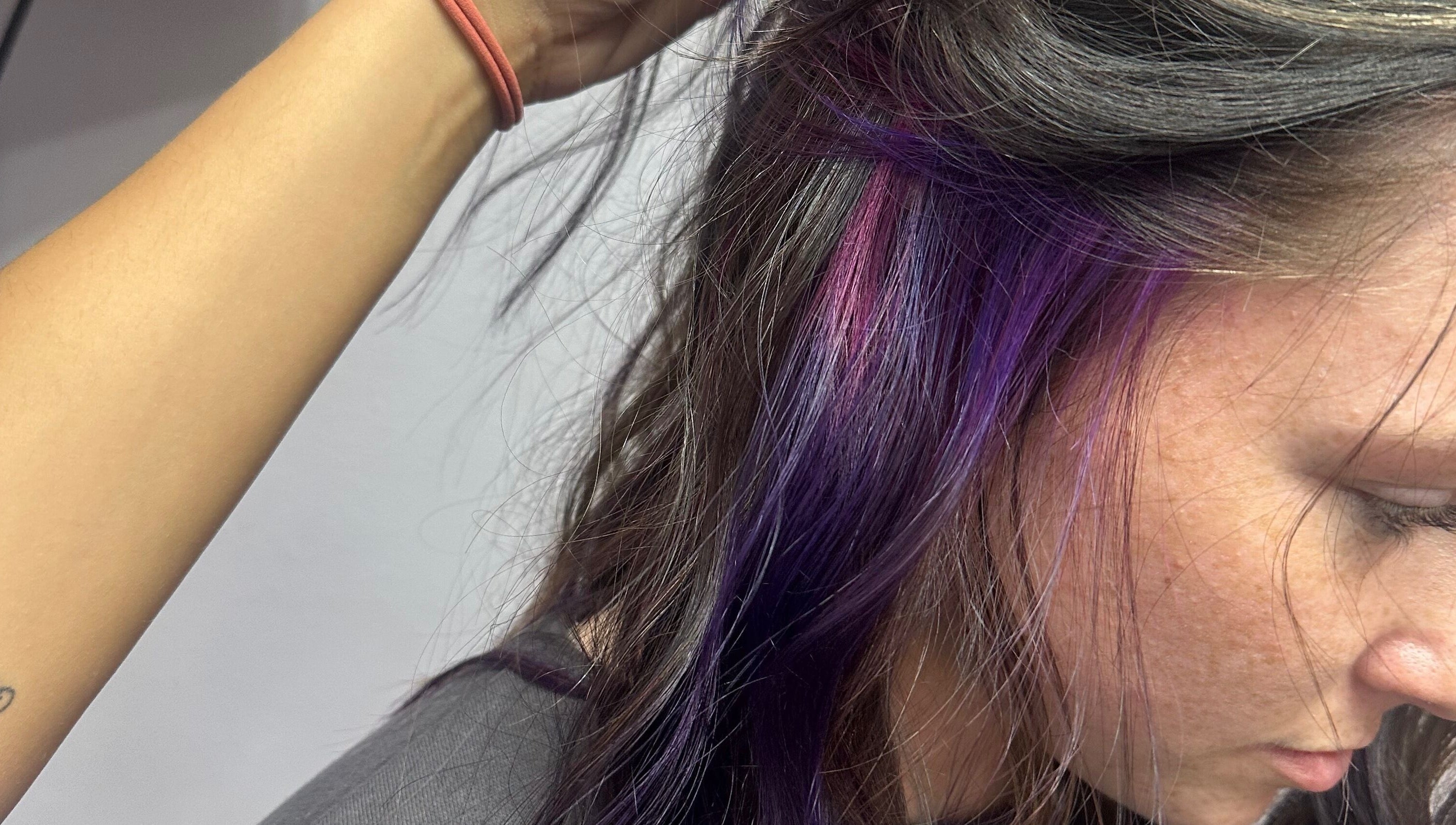 Purple and pink hair highlights at Tropical Rayz: Elena Garcia in Oskaloosa, Iowa, US.