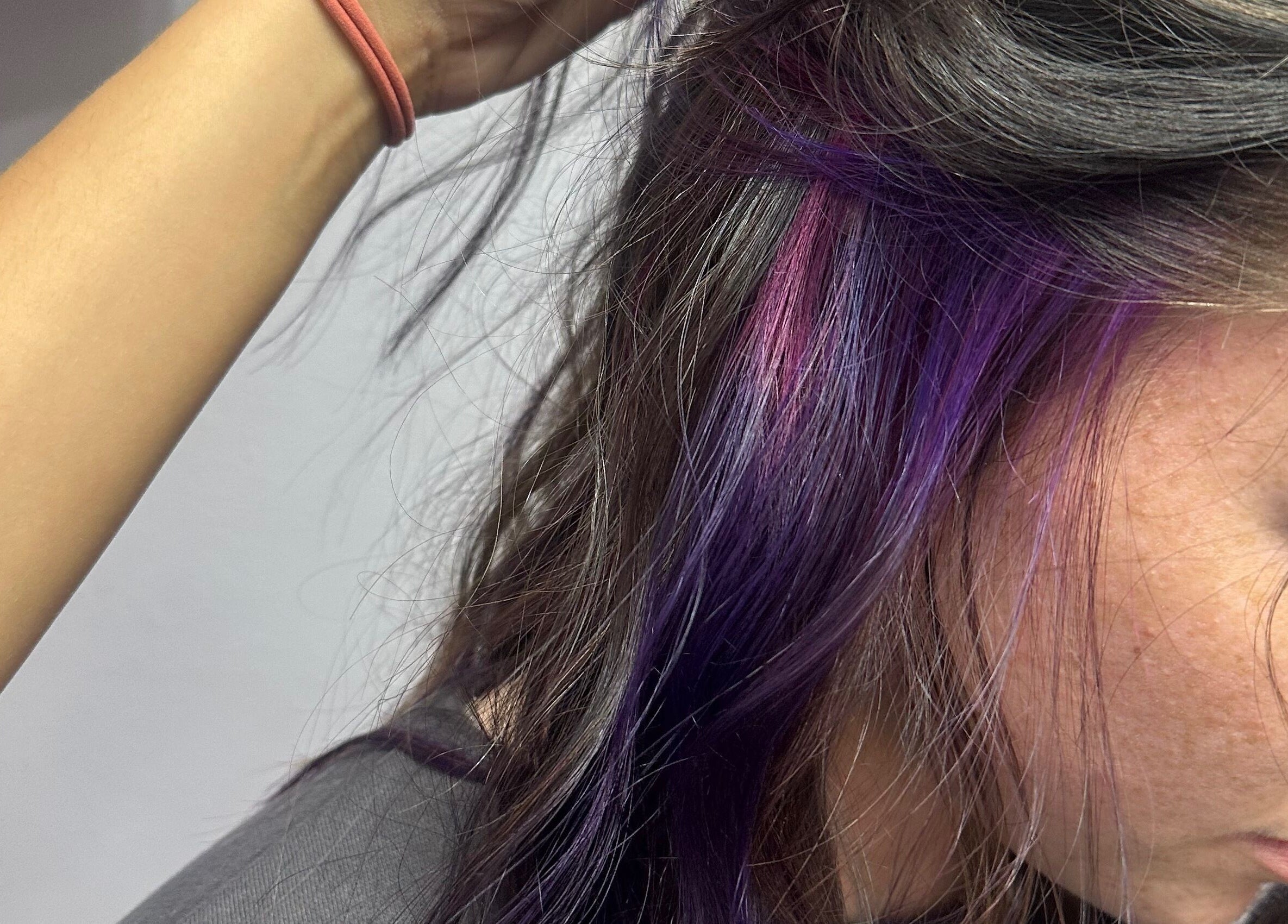 Purple and pink hair highlights at Tropical Rayz: Elena Garcia in Oskaloosa, Iowa, US.