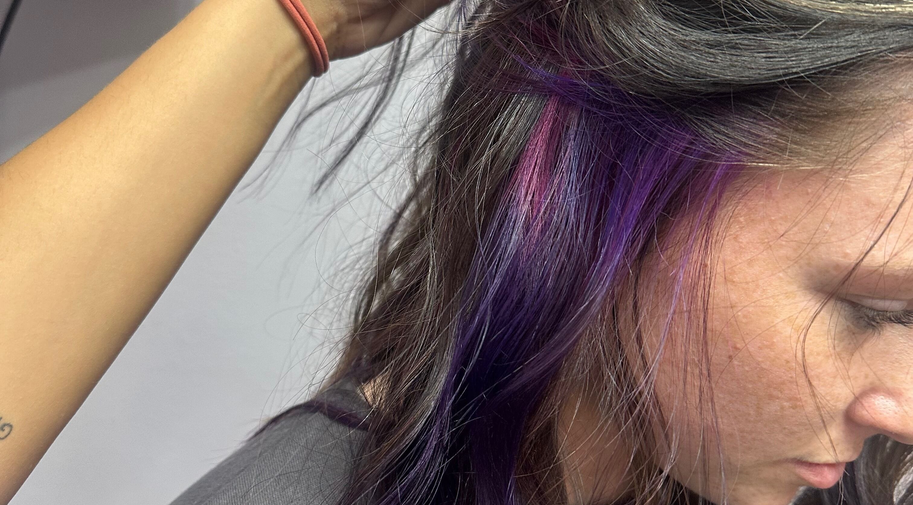 Purple and pink hair highlights at Tropical Rayz: Elena Garcia in Oskaloosa, Iowa, US.