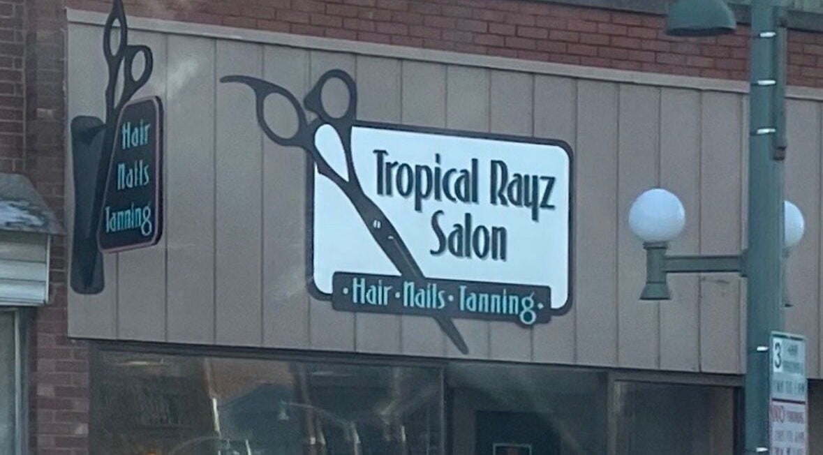Exterior of Tropical Rayz Salon by Elena Garcia in Oskaloosa, Iowa, US, featuring stylish signage.