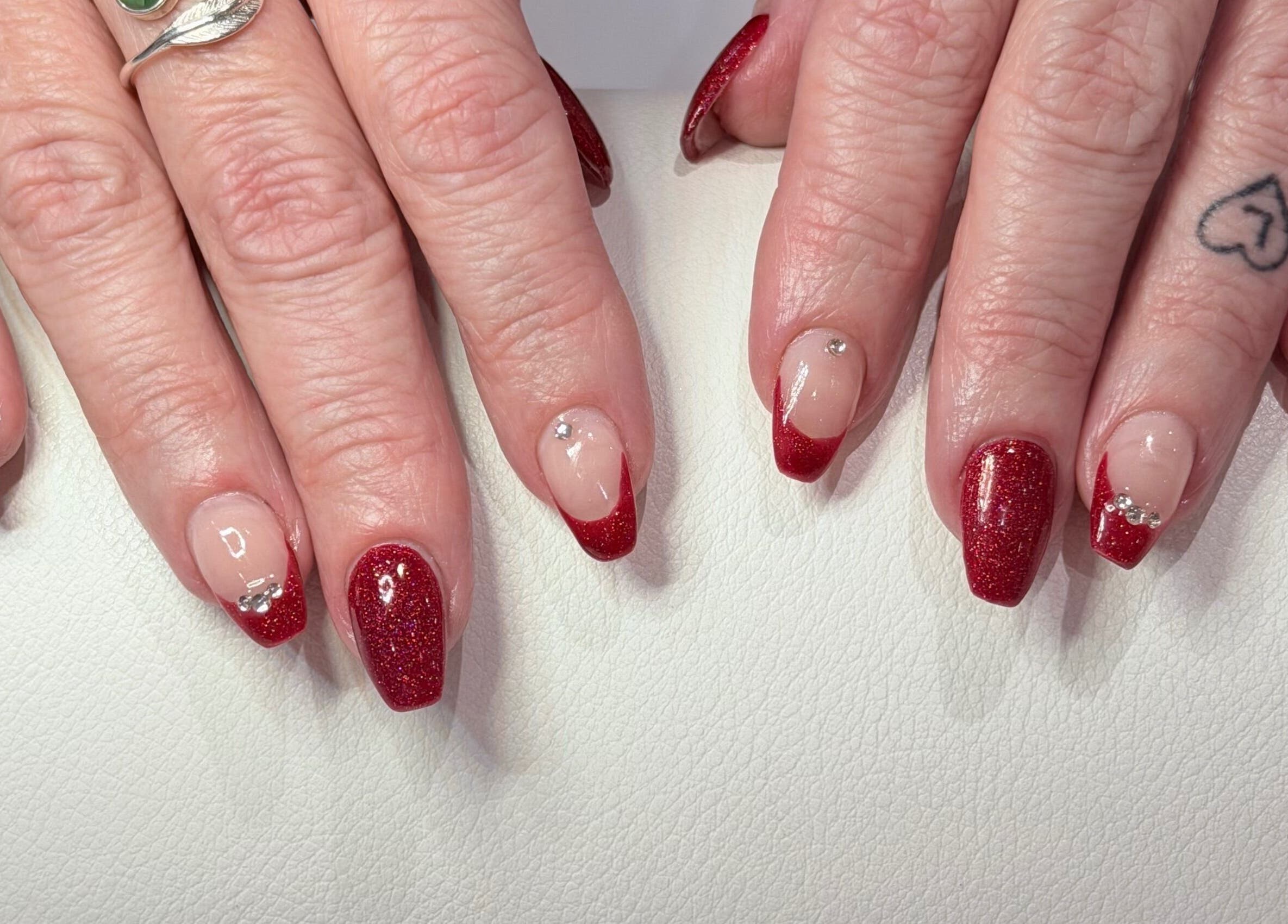 Red glitter manicure with rhinestones at Hampstead Medspa in London, England, GB.