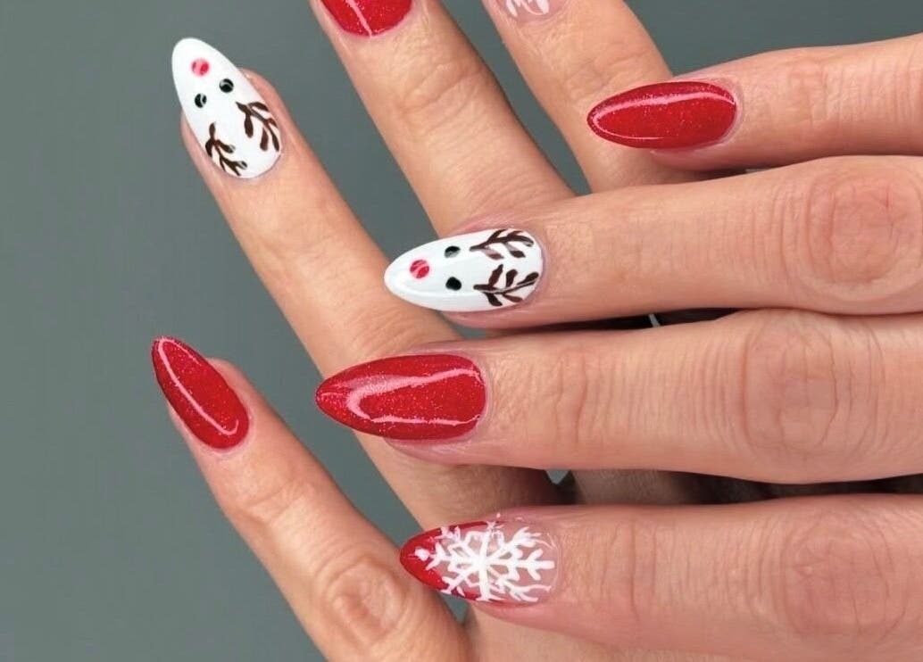 Festive nail art at Hampstead Medspa, London, England, GB showcases vibrant red and white designs.