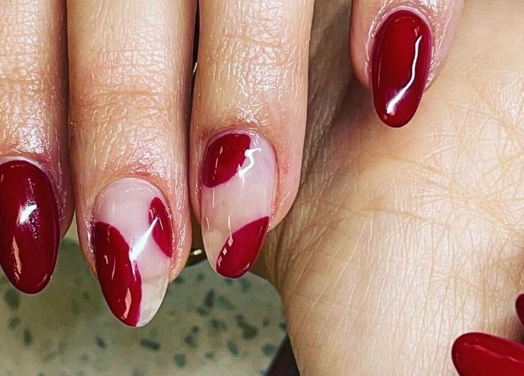 Stylish red manicure at Hampstead Medspa, London, England, GB, showcasing glossy crimson and clear nail art.