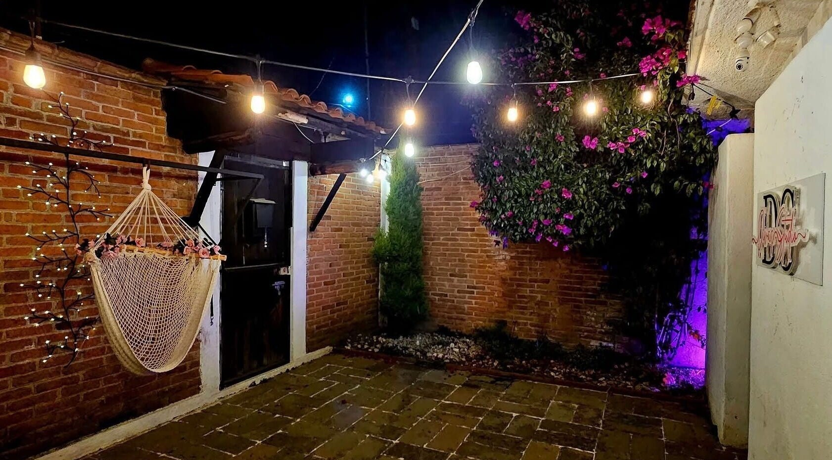 Ambiente nocturno del patio con hamaca y luces en DIMAR STUDIO, San Jorge Pueblo Nuevo, Estado De México, MX.