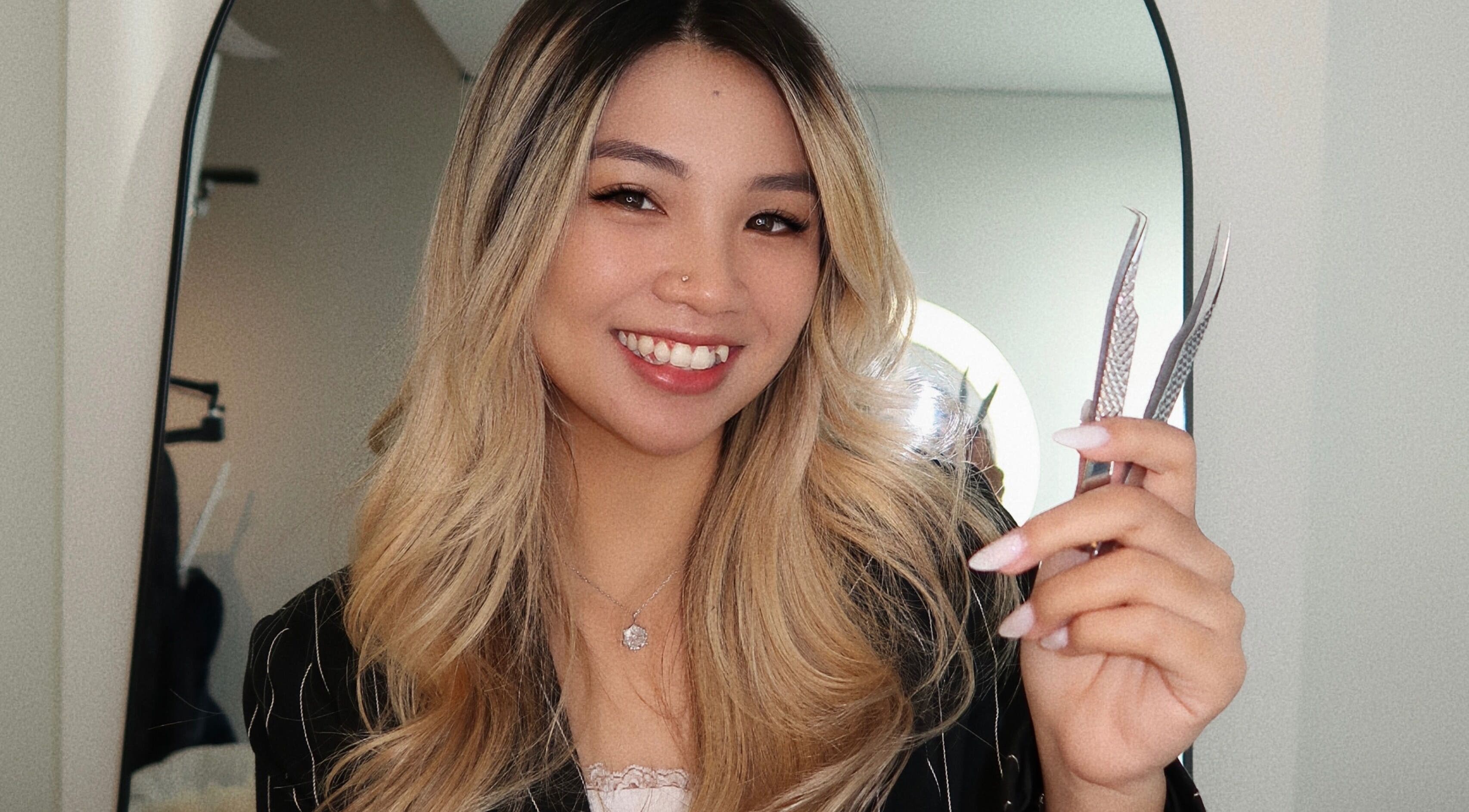 Smiling stylist holding lash tools at LASHBYRACHEL in Burnaby, British Columbia, CA.