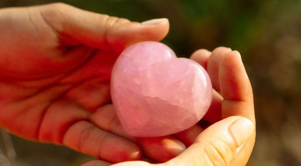 Rose quartz heart in hand at Languages of You, Bali, Bali, ID, symbolizing love and wellness.