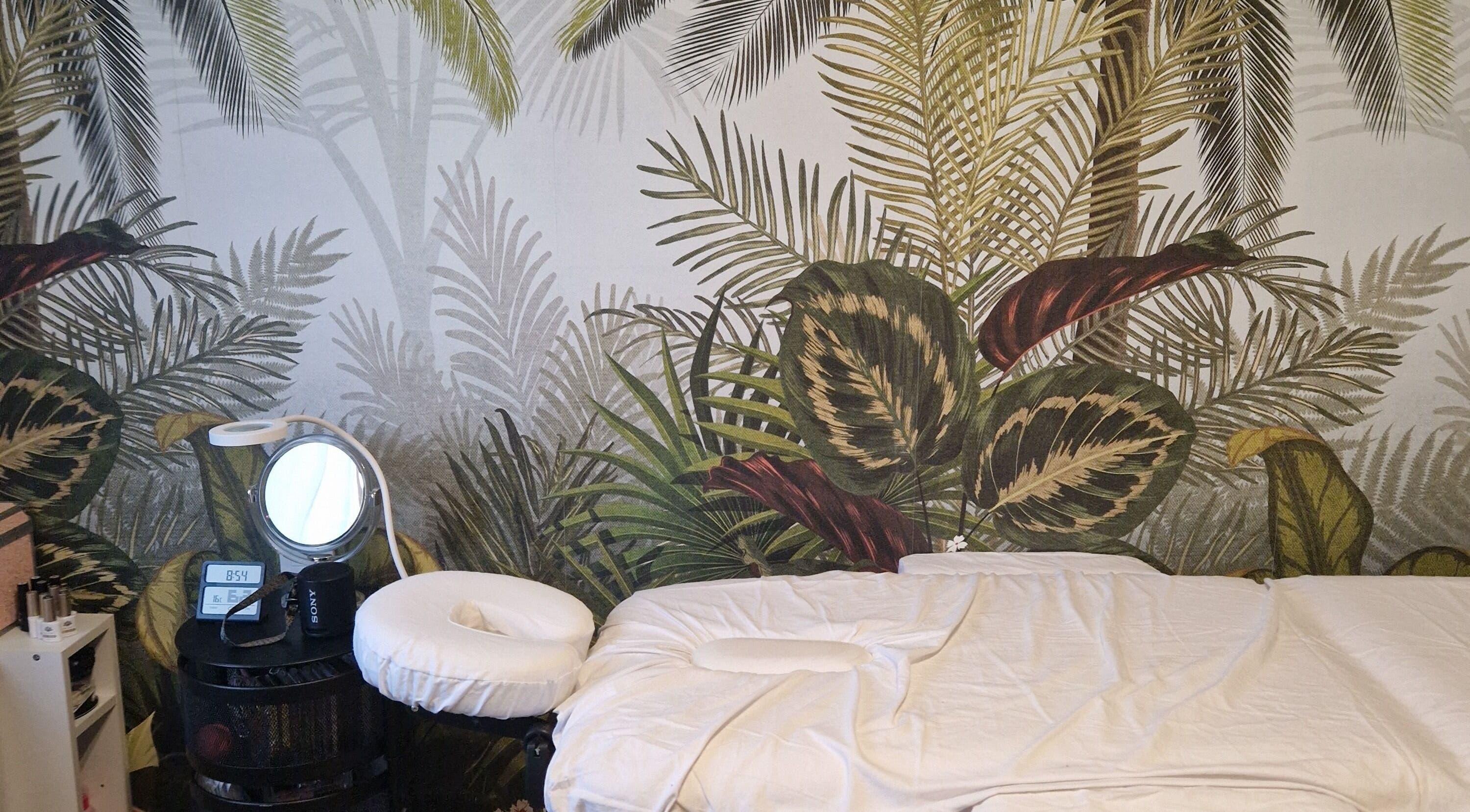 Salle de massage paisible chez Fée Moibel à Hastingues, Nouvelle-Aquitaine, FR avec décor à feuilles tropicales.