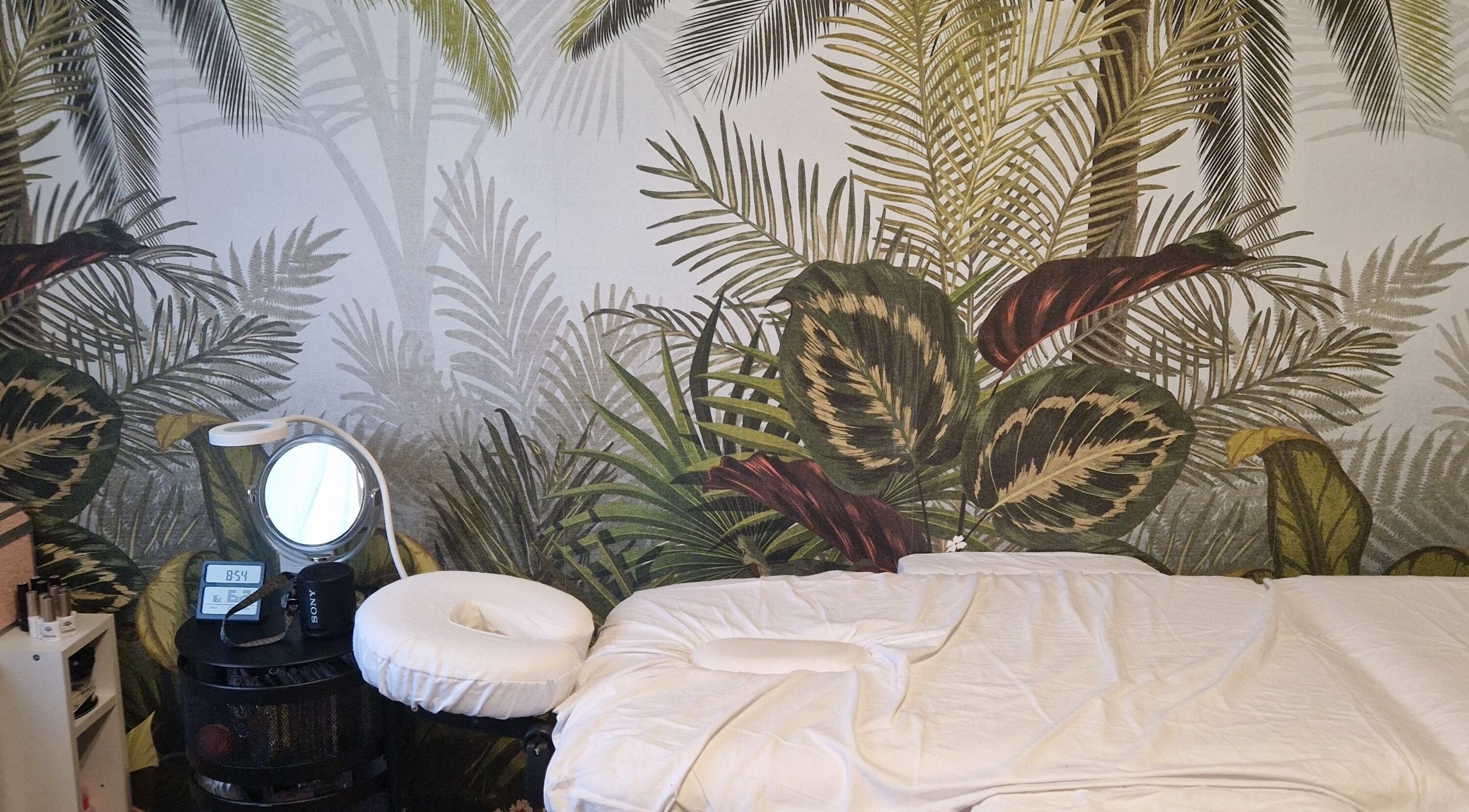 Salle de massage paisible chez Fée Moibel à Hastingues, Nouvelle-Aquitaine, FR avec décor à feuilles tropicales.