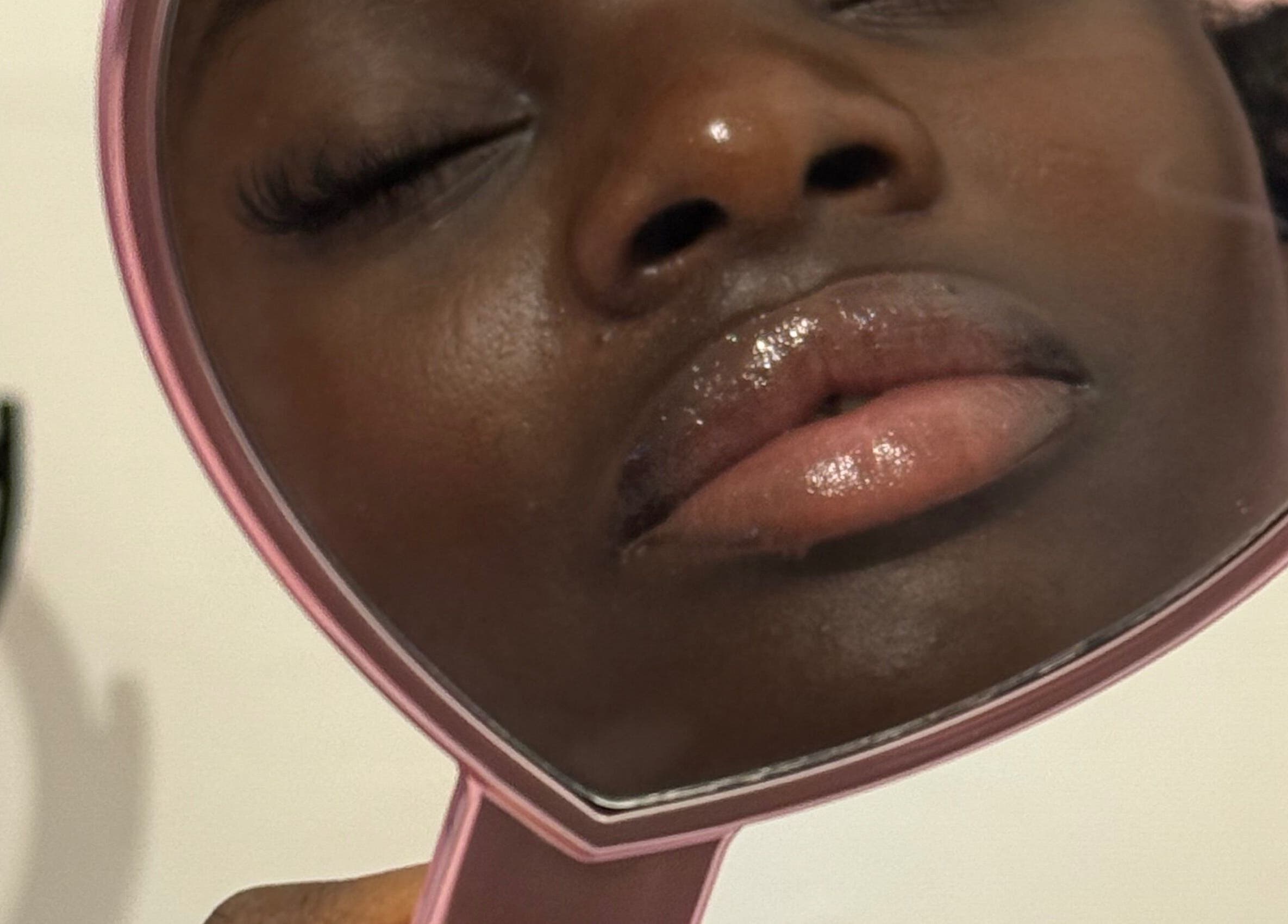 Close-up of glossy lips and lashes in mirror at Lashed By Daé, Cape Town, Western Cape, ZA.