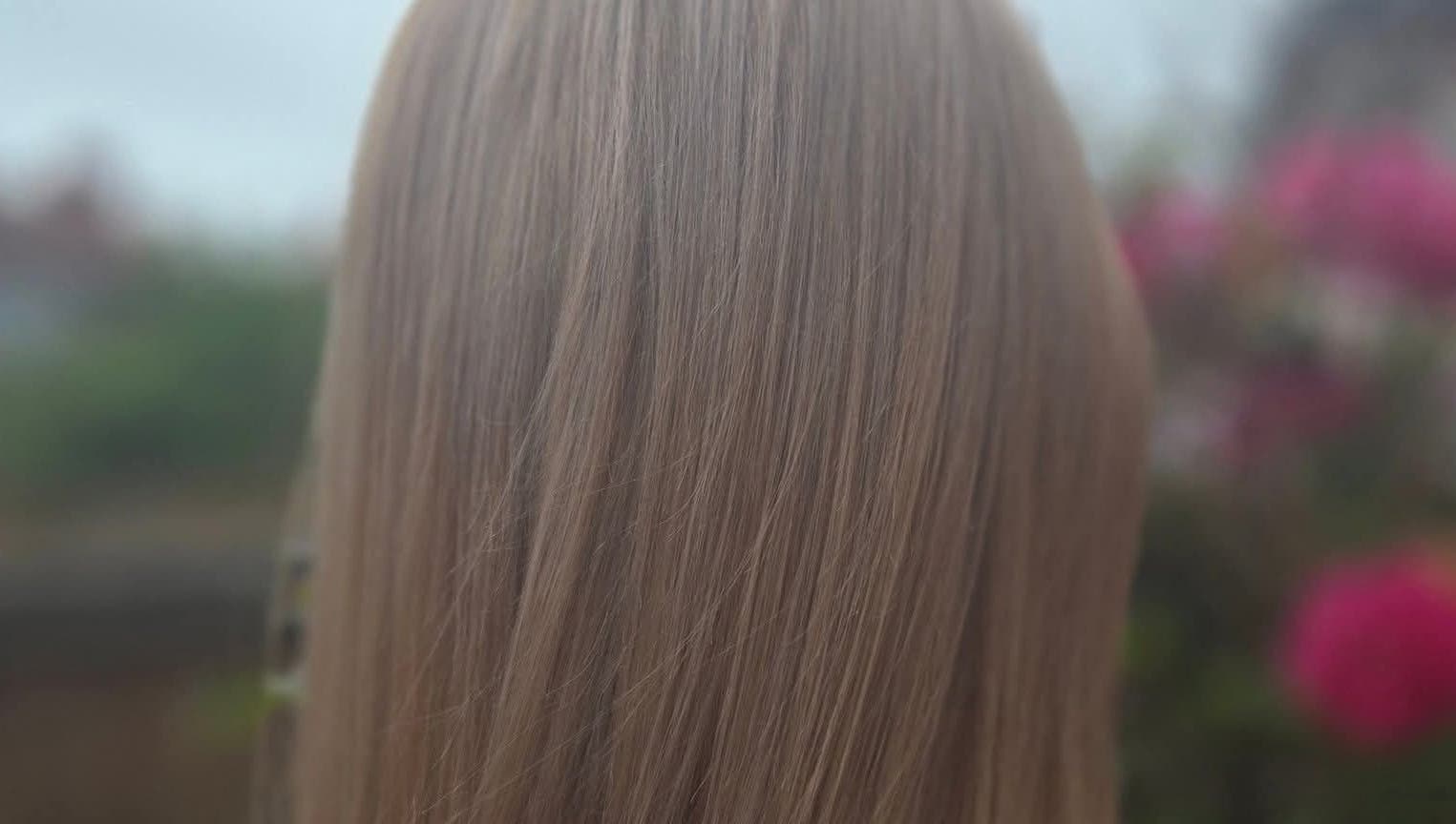 Close-up of silky hair at KF Hair Beauty Lifestyle in Fleetwood, England, GB, set against a soft outdoor backdrop.