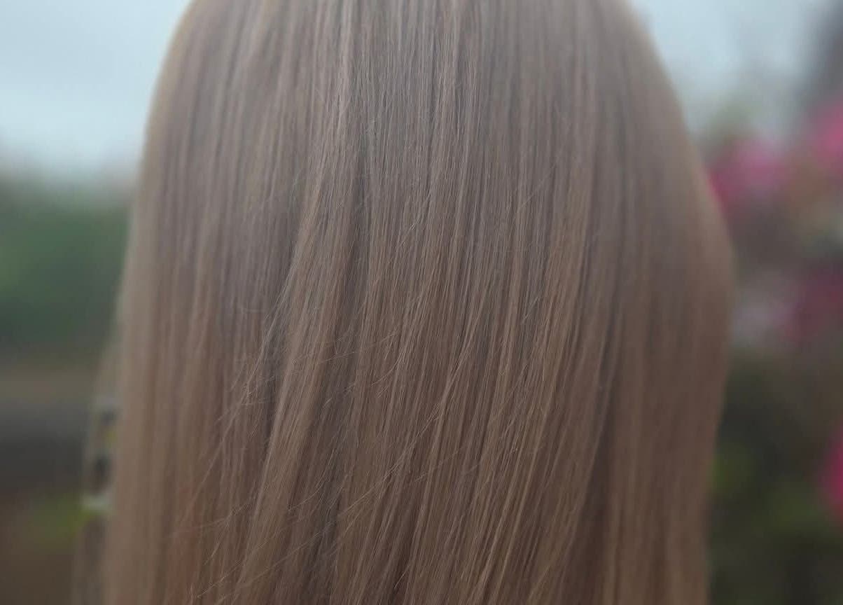 Close-up of silky hair at KF Hair Beauty Lifestyle in Fleetwood, England, GB, set against a soft outdoor backdrop.