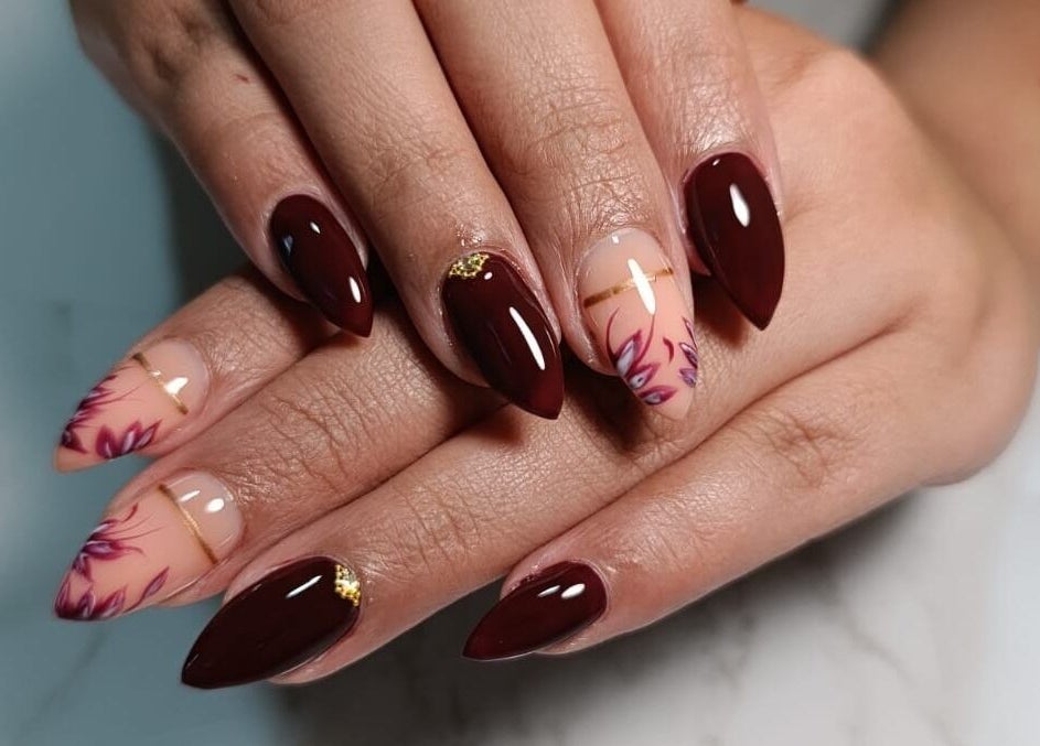 Detailed nail art with burgundy and floral designs by Petite Artistic Touch, Wanica, Wanica, SR.