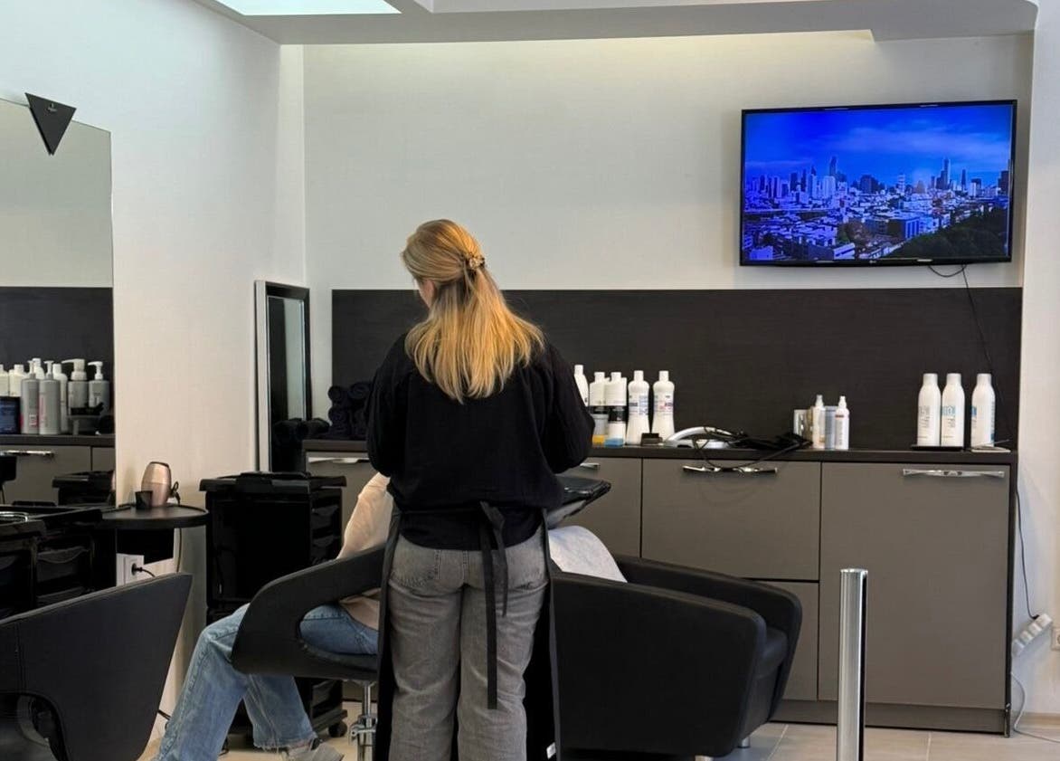 Интерьер салона LAVREN в Рига, LV, стилист работает с клиентом у зеркала.