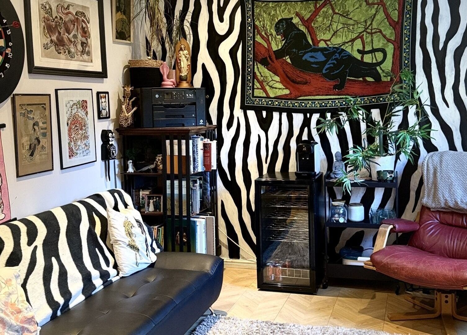 Eclectic lounge area at Laurs Claws in Bedford, England featuring zebra pattern decor and vibrant artwork.
