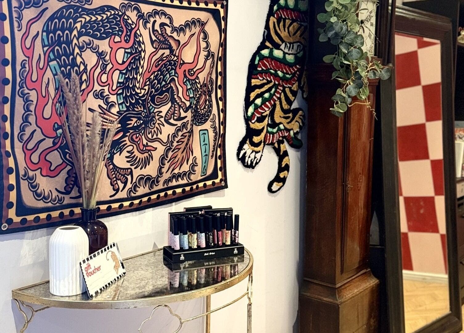 Artistic corner at Laurs Claws in Bedford, England, GB featuring vibrant wall art and nail polish display.
