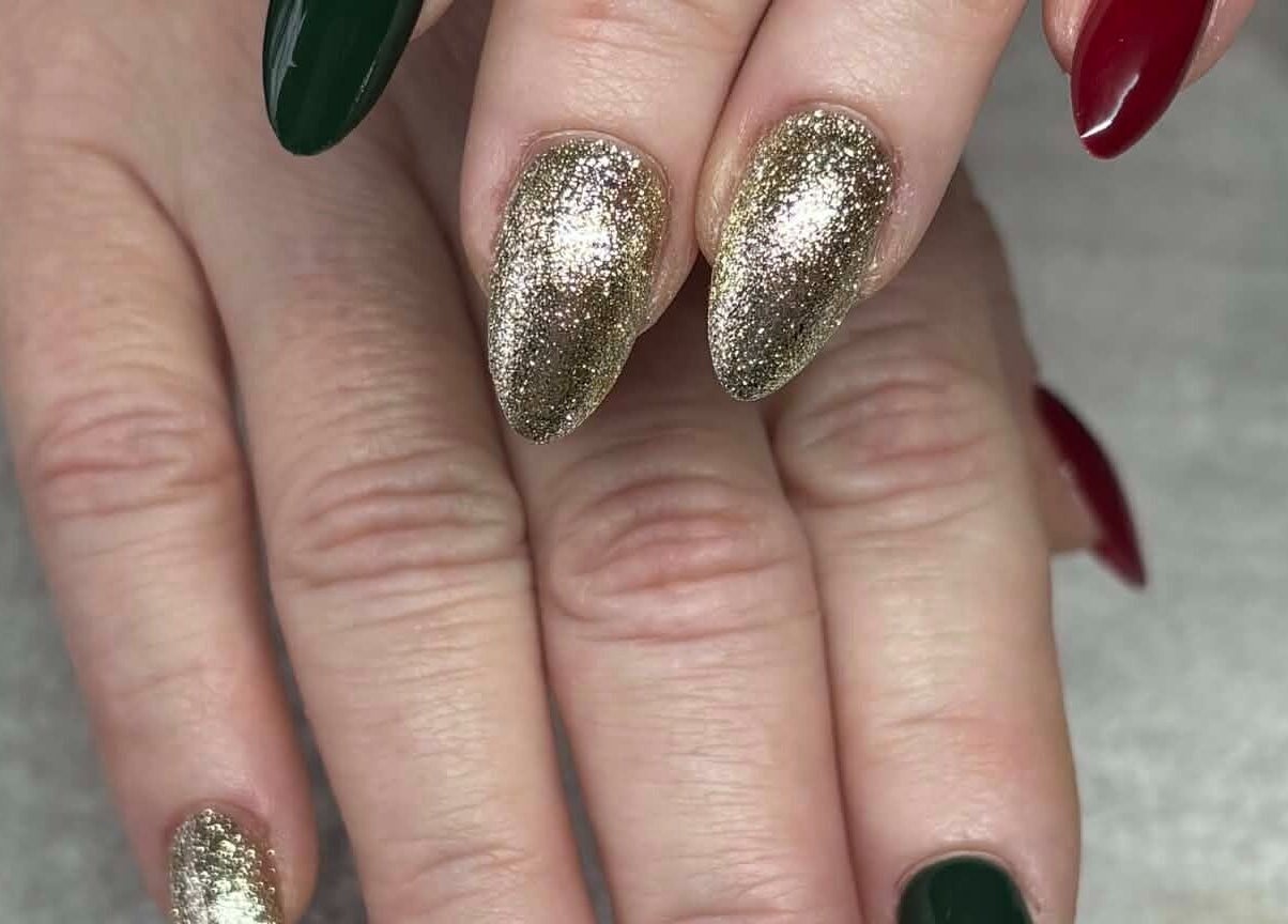 Elegant gold and dark nail art at Carli Esthetics, Cornwall, Ontario, CA enhancing a hand's beauty.