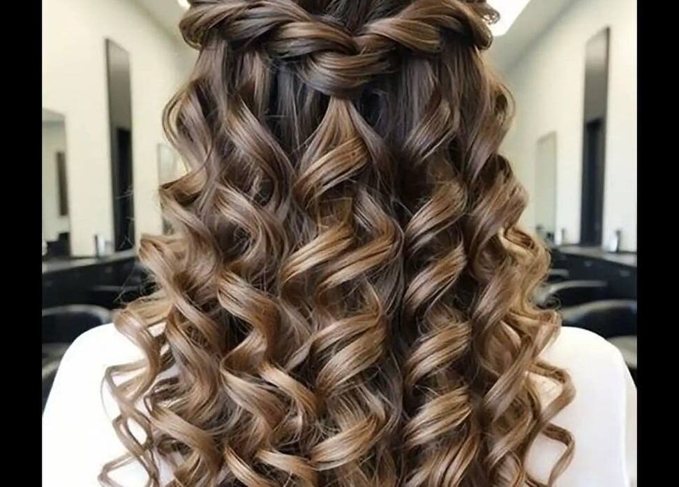 Elegant curly hairstyle at Test, IR salon showcasing expert styling with a chic braid highlight.