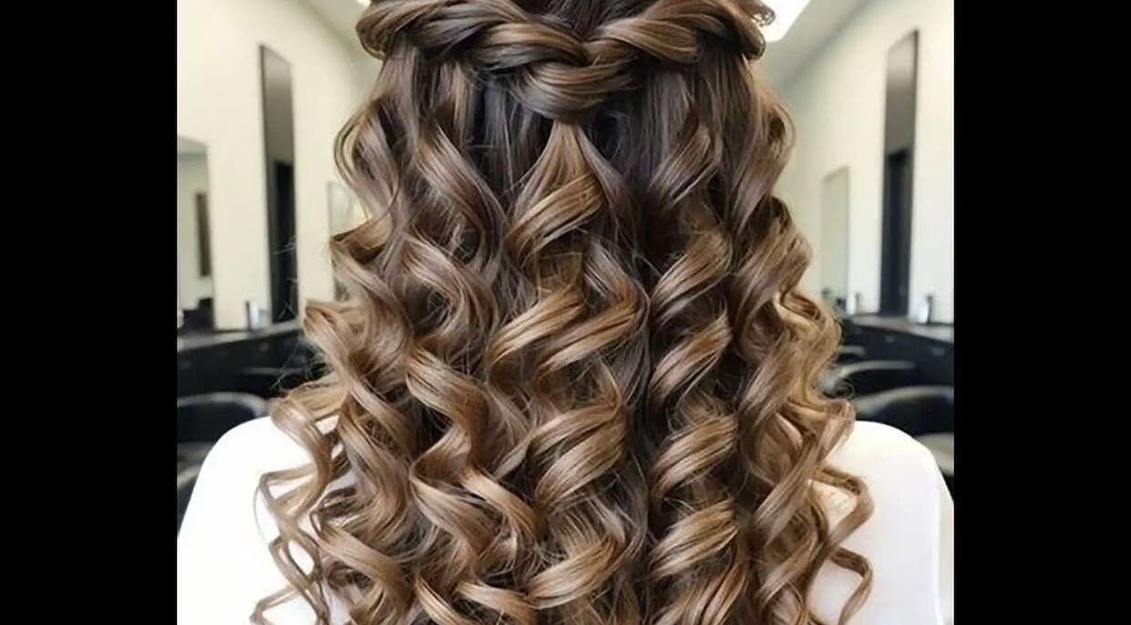 Elegant curly hairstyle at Test, IR salon showcasing expert styling with a chic braid highlight.