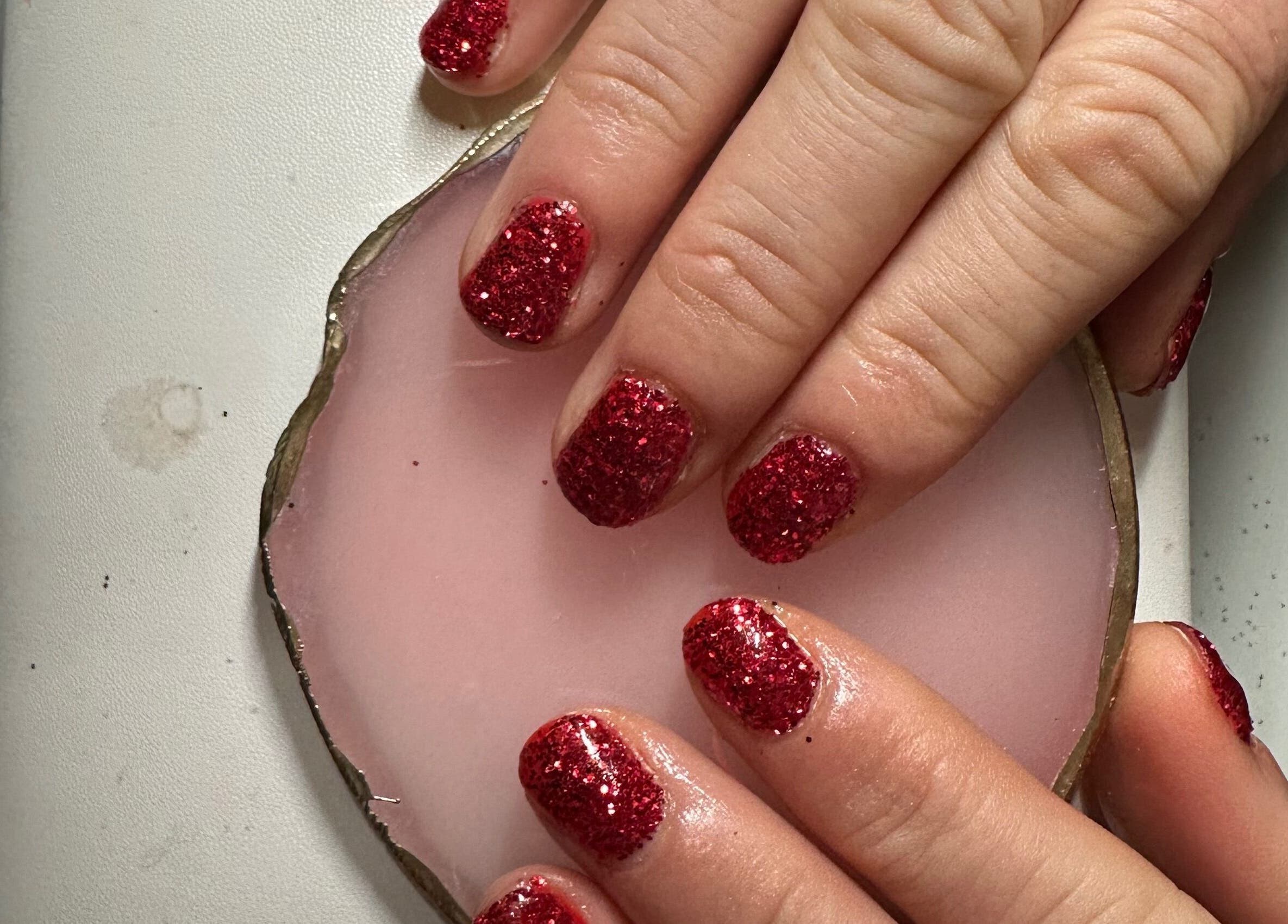 Red glitter nails on a soft pink pad at Beauty By Payton, Sunderland, England, GB.