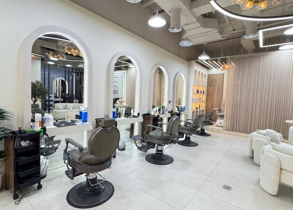 Modern interior of Three Brothers Barbershop in Sharjah, AE featuring stylish barber chairs and large mirrors.