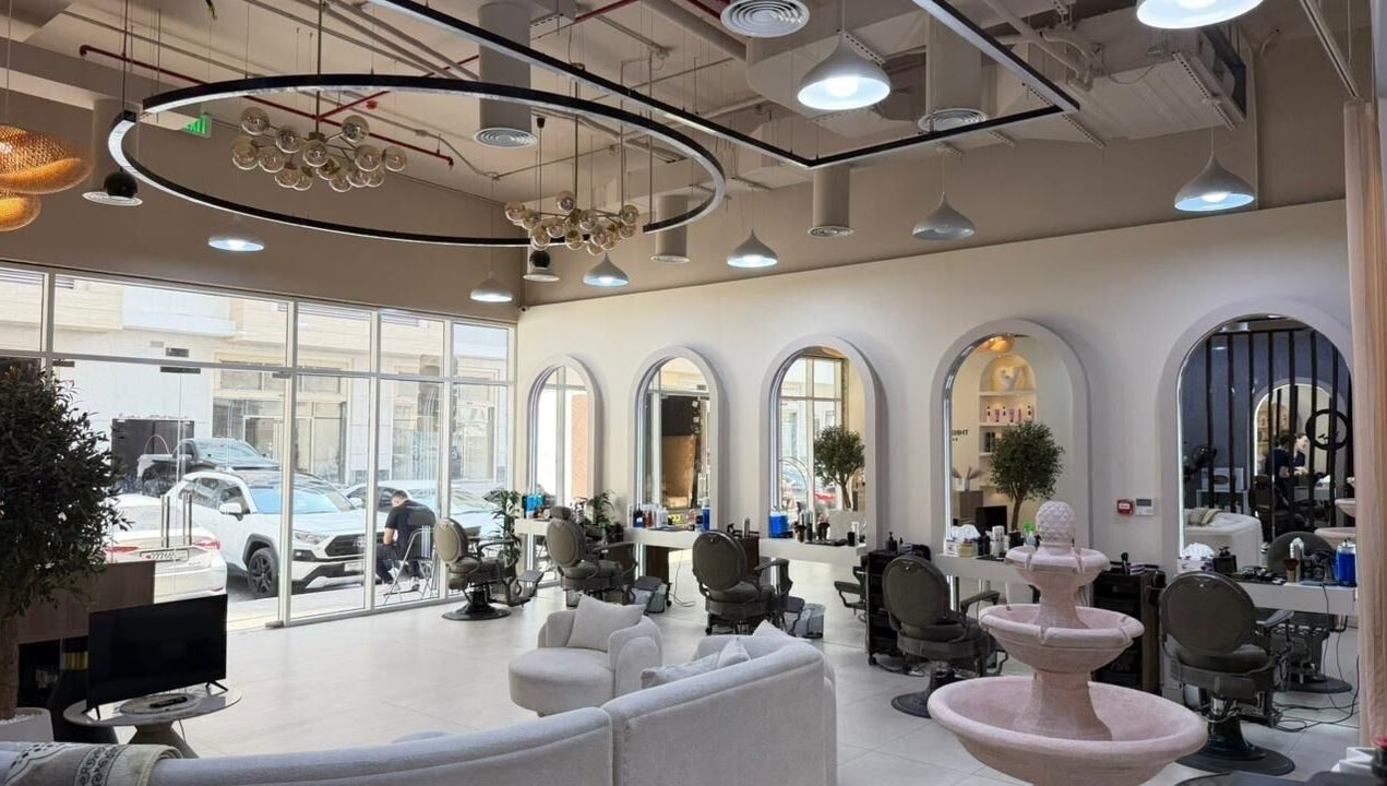 Spacious interior of Three Brothers Barbershop in Sharjah, AE, showcasing modern decor and stylish seating.