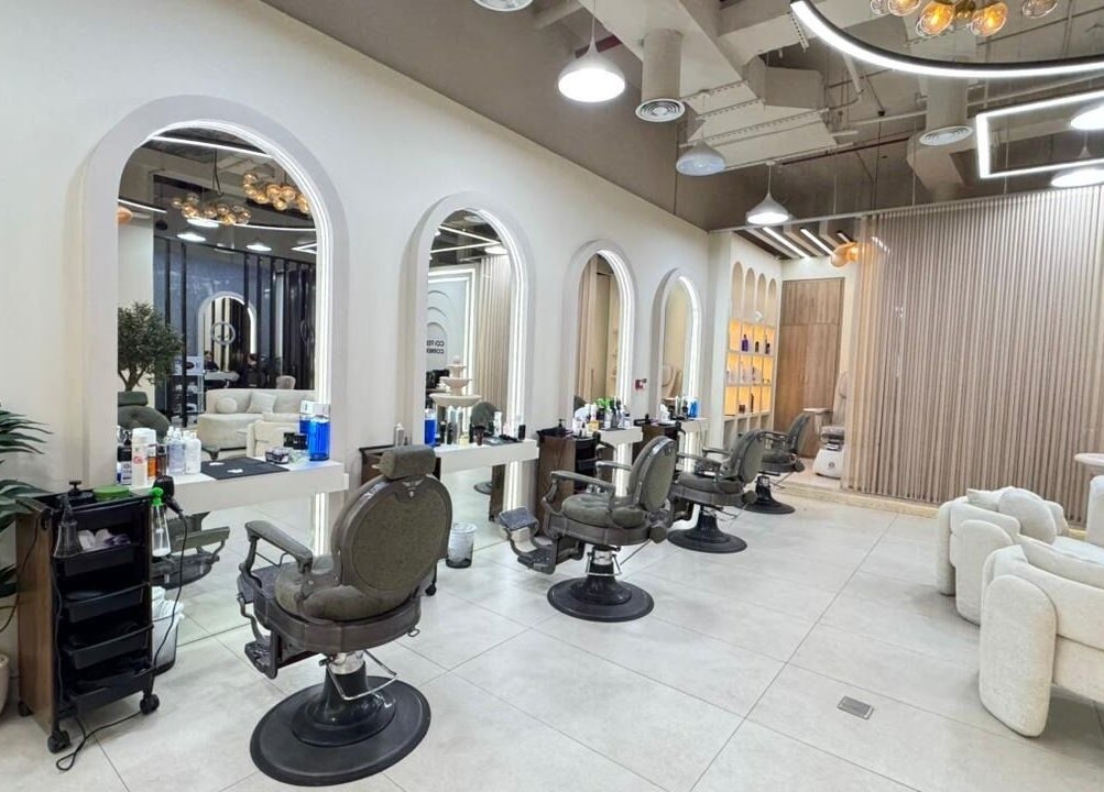 Spacious interior of Three Brothers Barbershop in Sharjah, AE, featuring chic barber chairs and stylish decor.