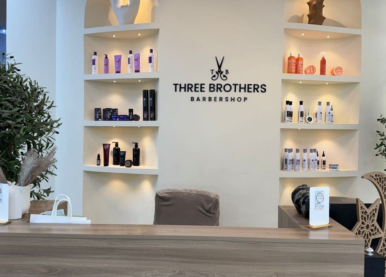 Reception area of Three Brothers Barbershop in Sharjah, AE, featuring stylish shelves with grooming products.