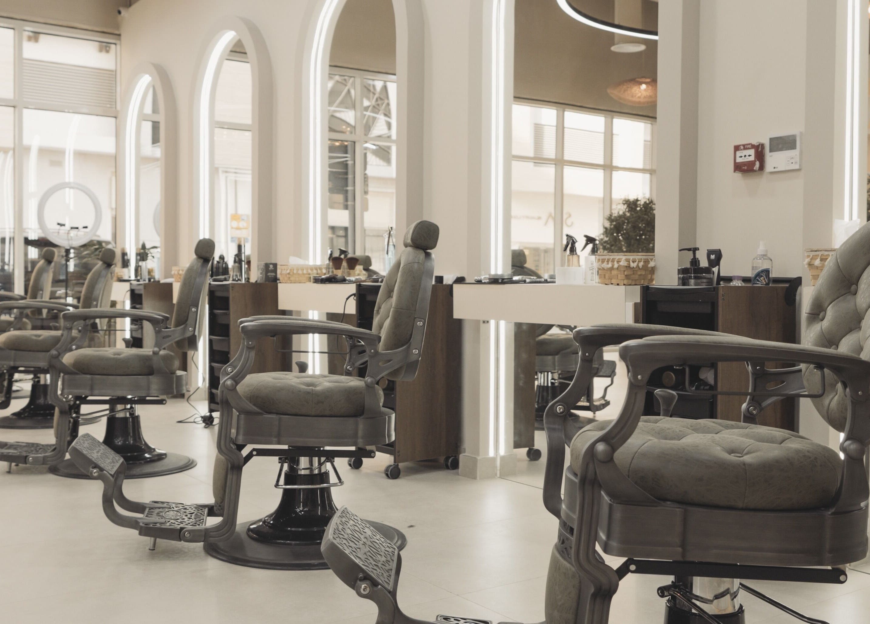 Modern interior of Three Brothers Barbershop, Sharjah, AE with stylish barber chairs and mirrors.