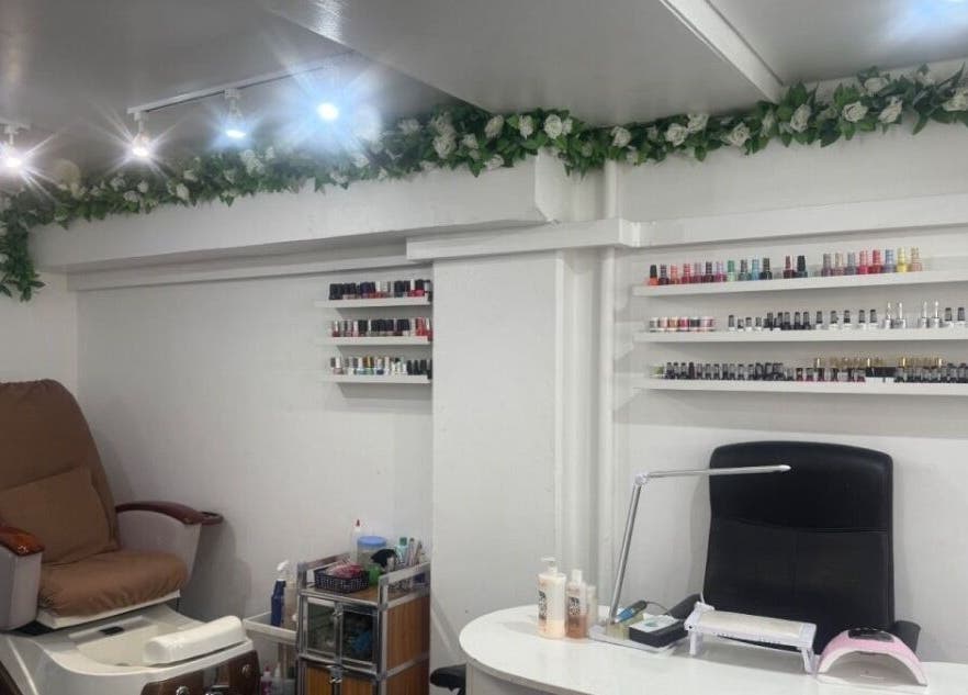 Cozy nail salon corner at NailsbyHarman, London, England, GB with nail polish displays and pedicure chair.