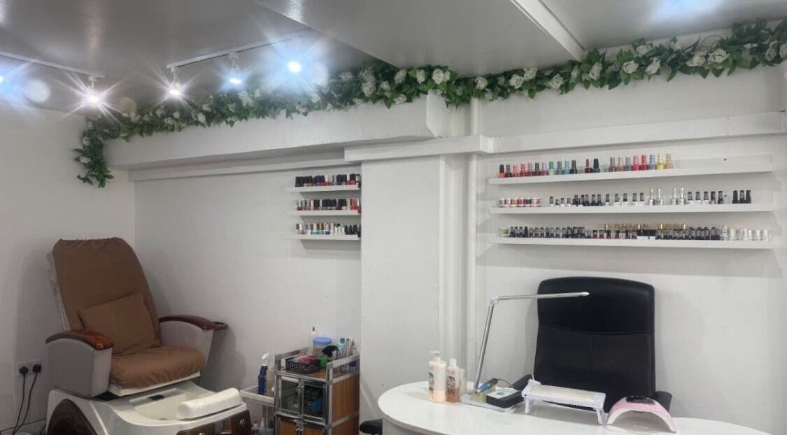 Cozy nail salon corner at NailsbyHarman, London, England, GB with nail polish displays and pedicure chair.