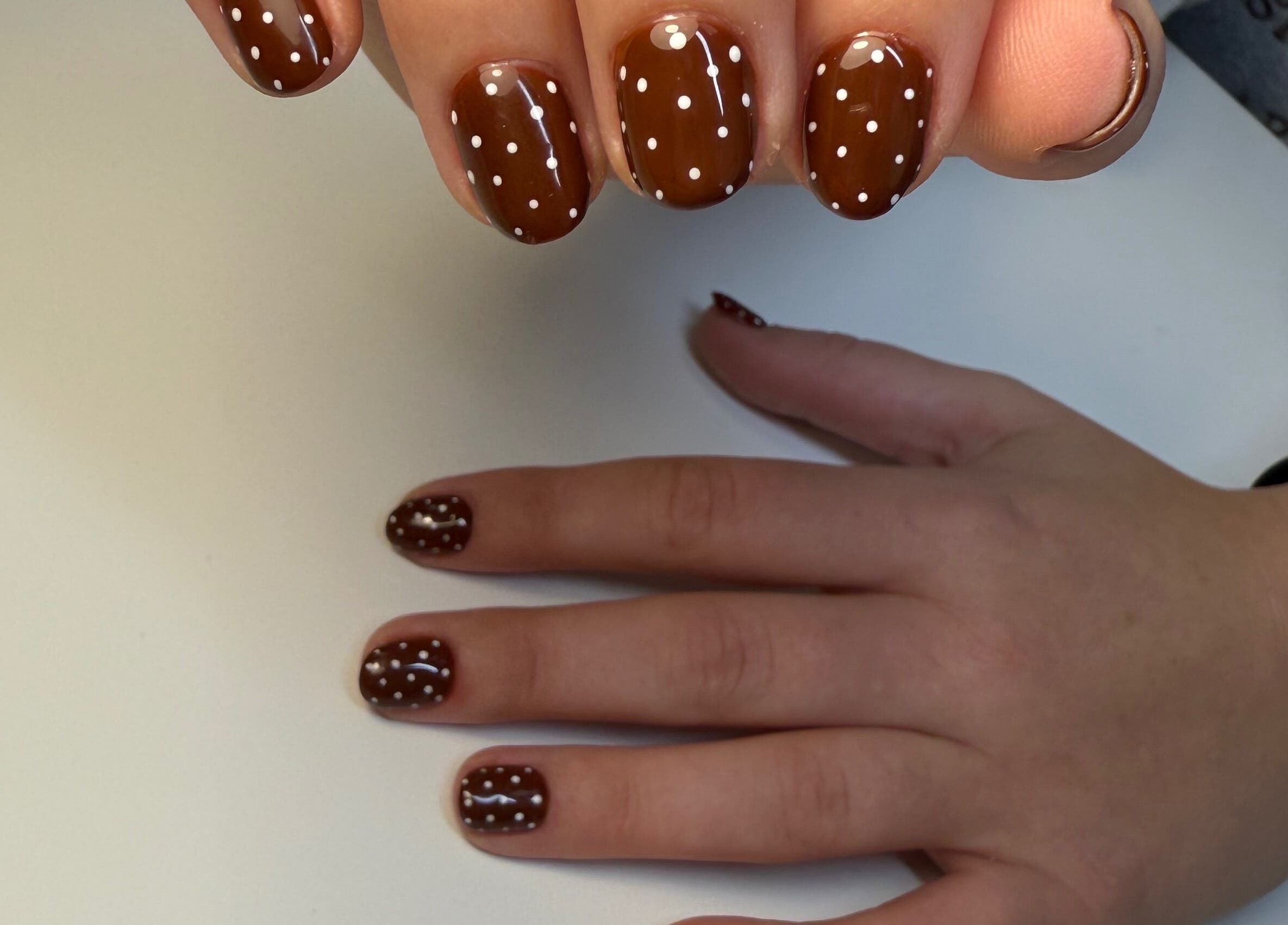 Polished nails with brown and white polka dot design at Eyra Studio Nails, Chandler, Arizona, US.