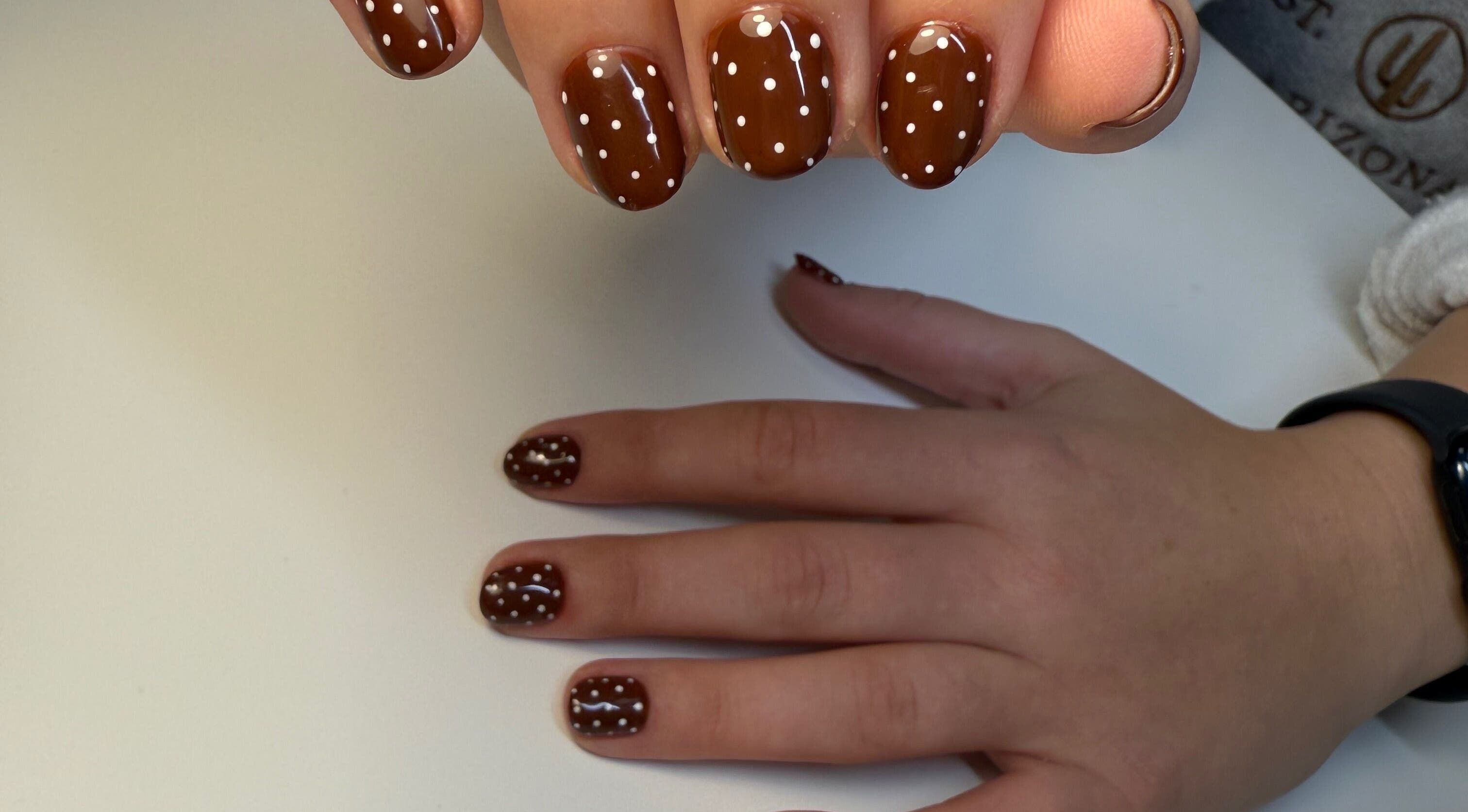 Polished nails with brown and white polka dot design at Eyra Studio Nails, Chandler, Arizona, US.