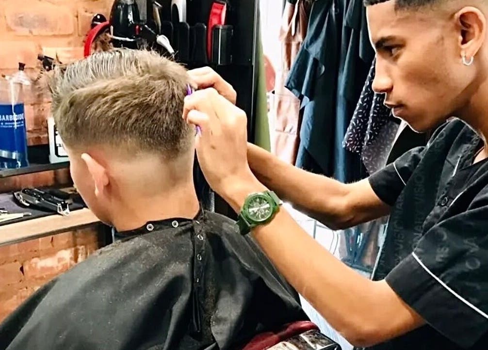 Barber at Xdabarber in Pretoria, Gauteng, ZA skillfully cutting a client's hair.