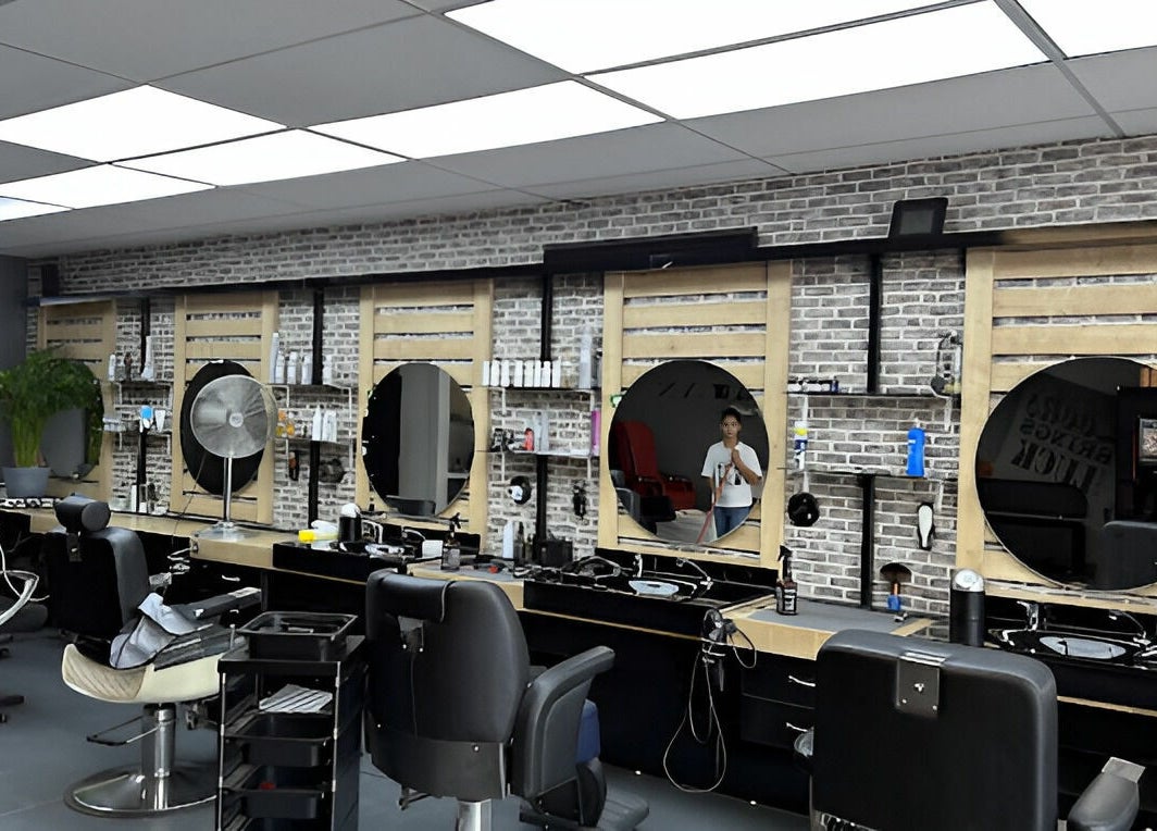 Moderne kappersstoelen bij Golden Shavette, Uithoorn, Noord-Holland, NL met spiegelwand en gereedschappen.