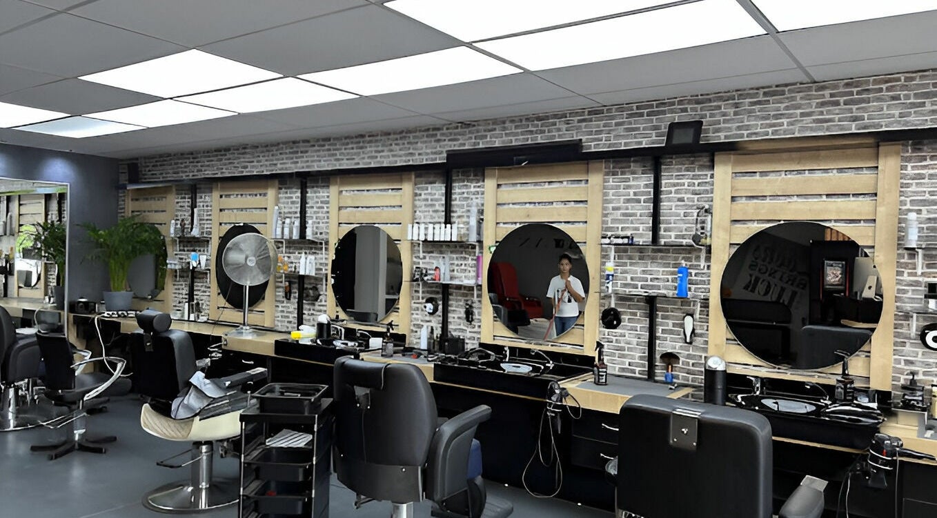 Moderne kappersstoelen bij Golden Shavette, Uithoorn, Noord-Holland, NL met spiegelwand en gereedschappen.