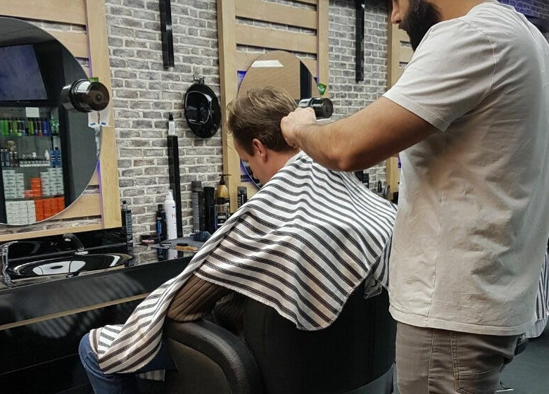 Kapster bij Golden Shavette in Uithoorn, Noord-Holland, NL geeft een knipbeurt in moderne salon.