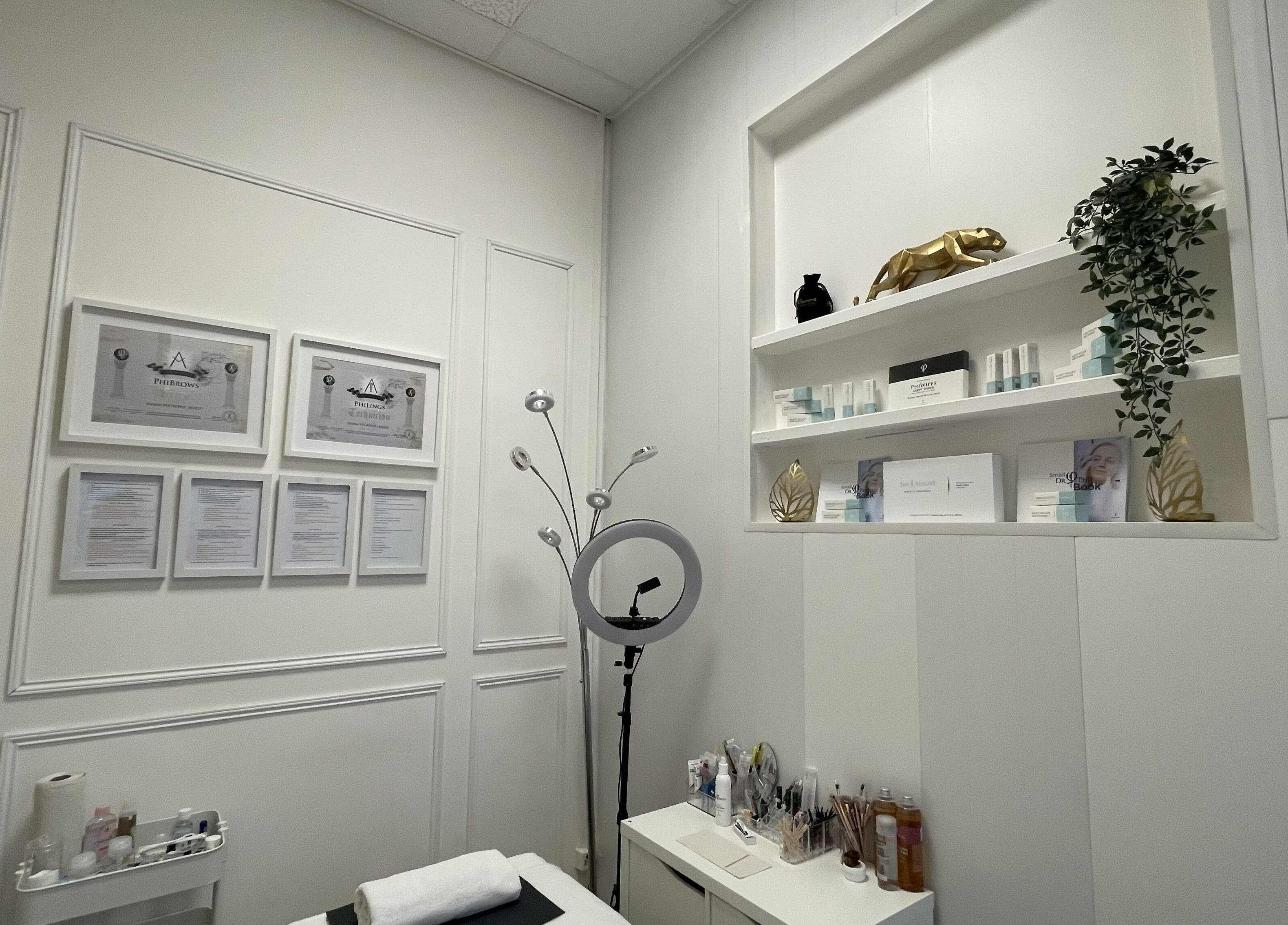 Serene interior of JVB Beauty & The Brows in Genève featuring framed certificates and beauty products.