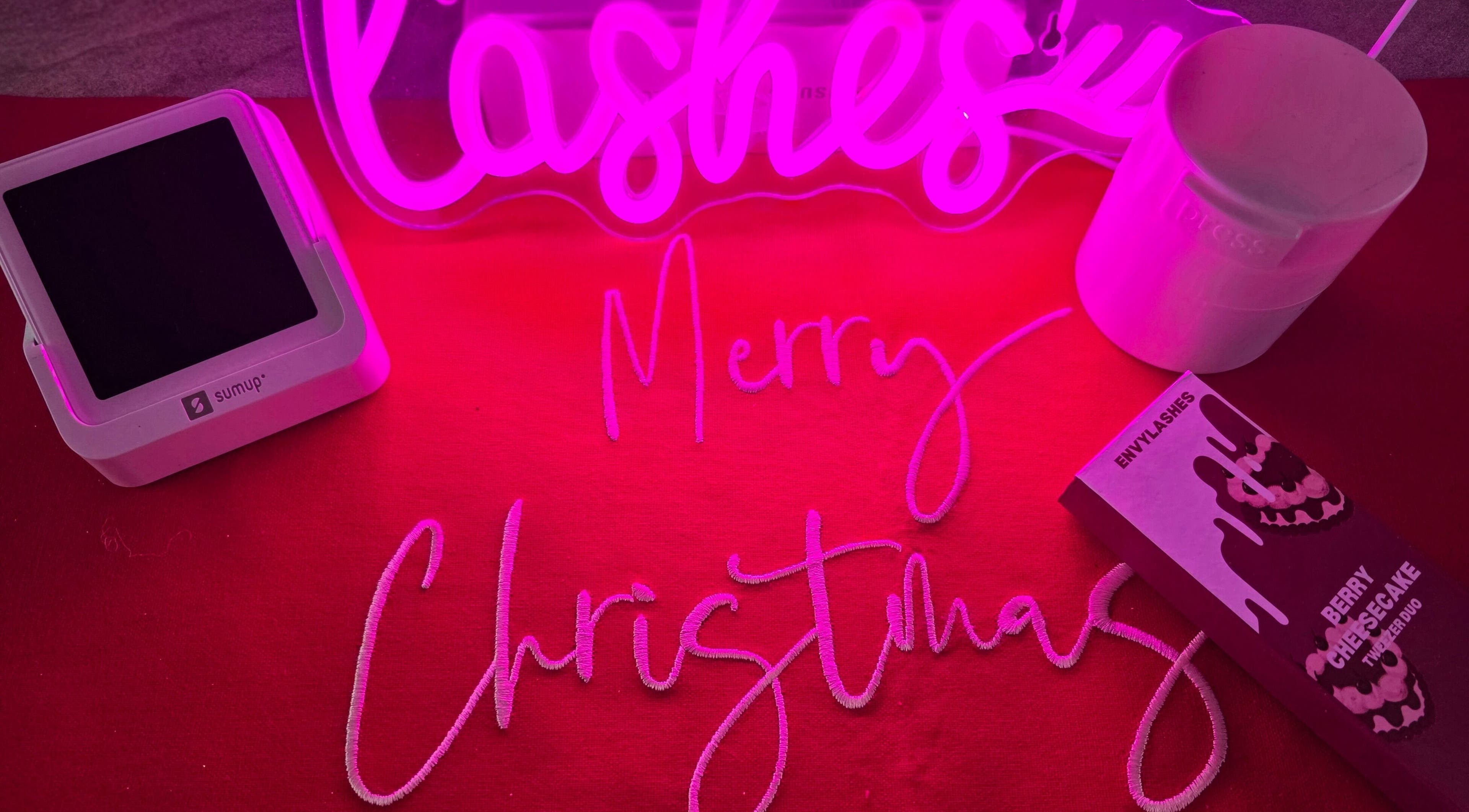 Pretty little beauty in Pembroke, Wales, GB, celebrates with festive decor and products under a pink glow.