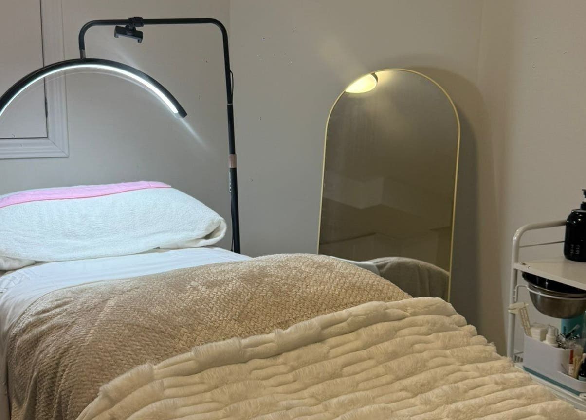 Cozy treatment room at Femme Beauty, Aurora, Ontario, CA, with plush bedding and skincare tools.