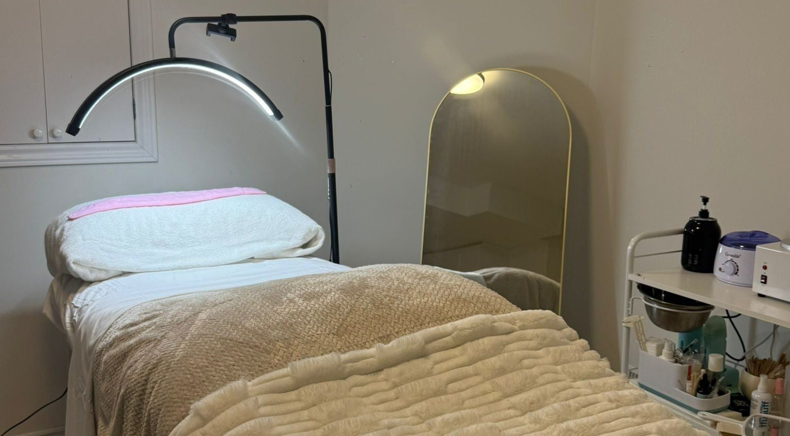 Cozy treatment room at Femme Beauty, Aurora, Ontario, CA, with plush bedding and skincare tools.