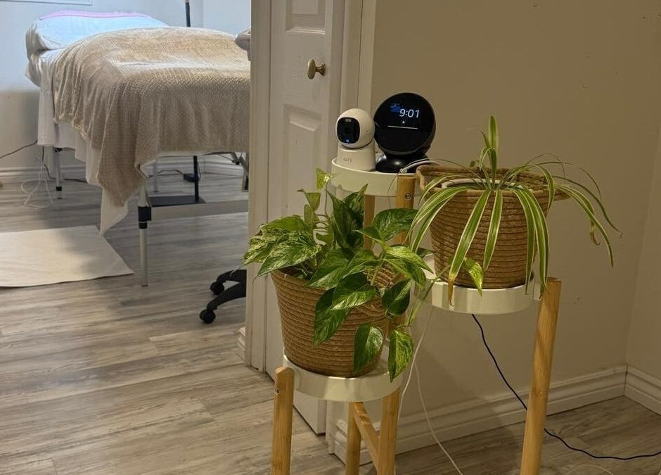 Peaceful treatment room at Femme Beauty in Aurora, Ontario, CA with plants and massage bed.