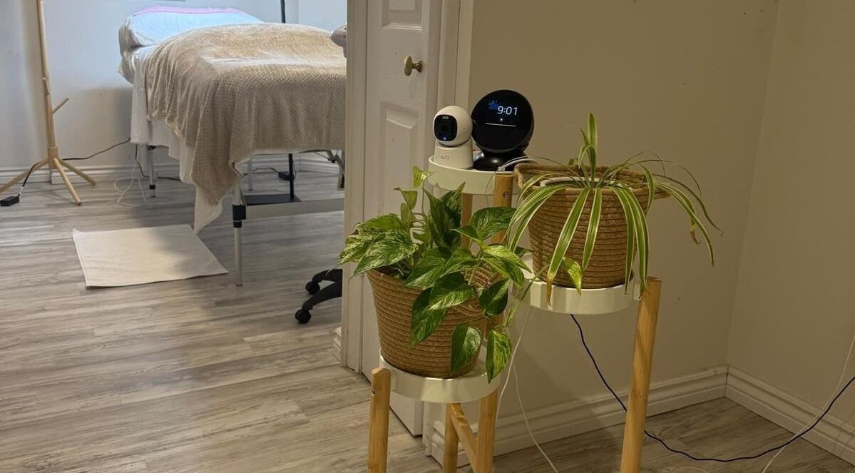 Peaceful treatment room at Femme Beauty in Aurora, Ontario, CA with plants and massage bed.