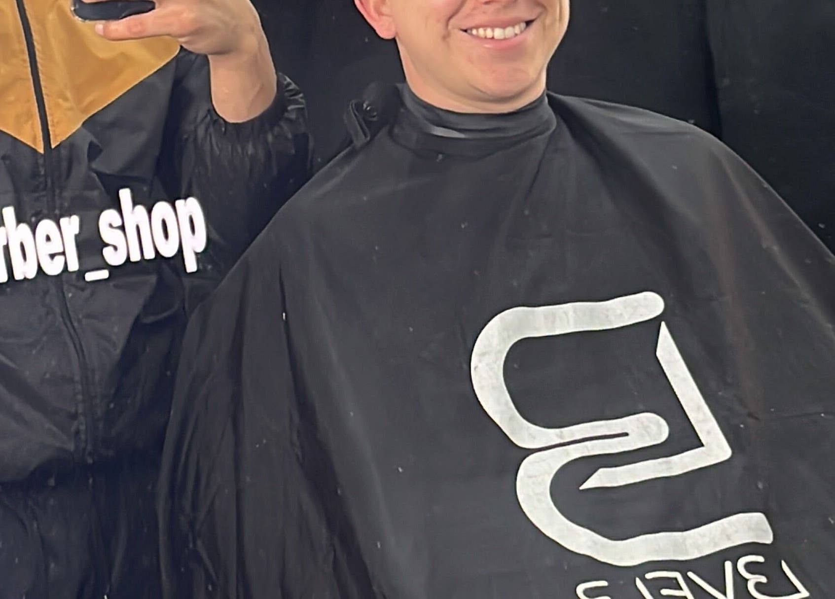 Cliente sonríe con satisfacción tras corte en J Alex Barber Shop, Peñalolén, Región Metropolitana, CL.