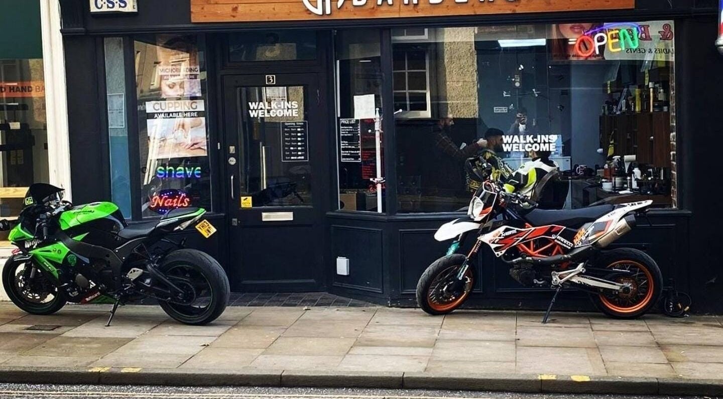 EH BARBERS Dalkeith, Scotland shopfront showcasing motorcycles outside its welcoming entrance.