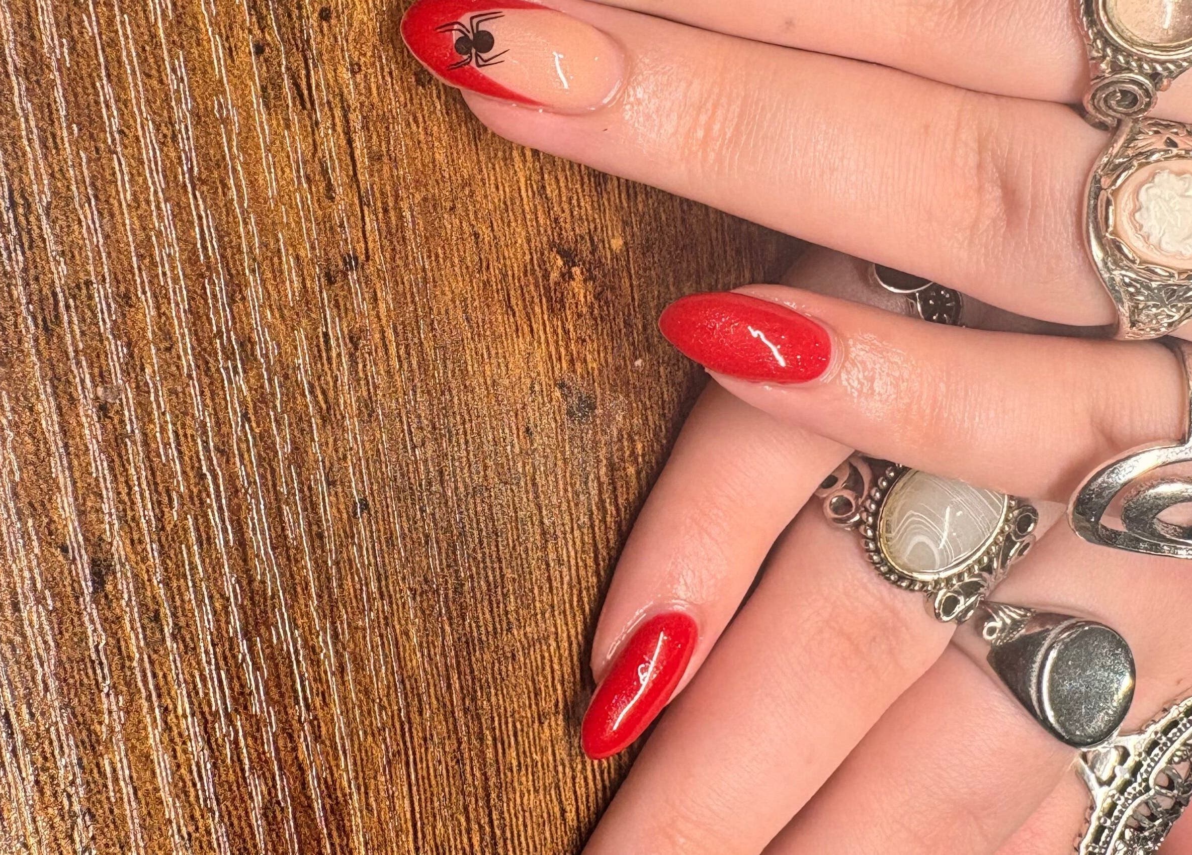 Stylish red nails with rings at Nailed It By Ameena, Shrewsbury, England, GB.