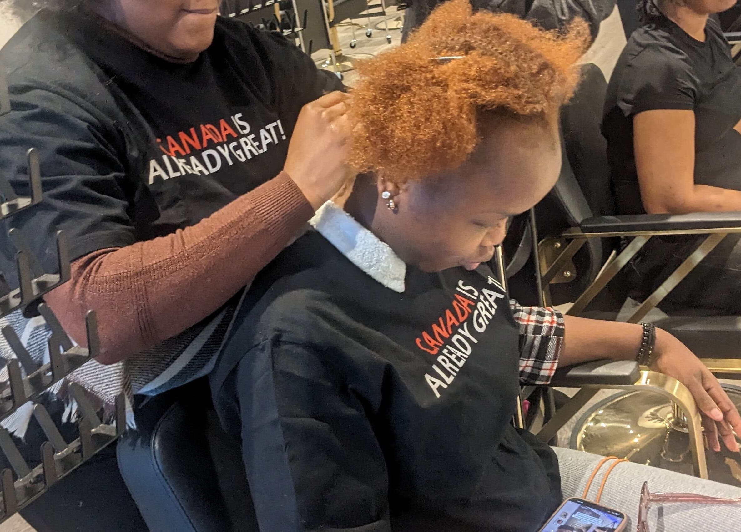 Coiffeuse à Tresses Express inc. à Montréal, Québec, CA, travaillant sur les cheveux d'un client.