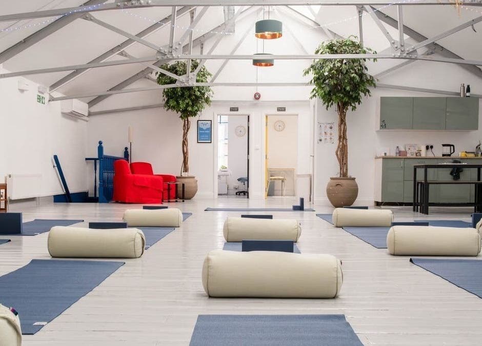 Tranquil yoga studio at Idle Hands Massage Therapy, London, England, GB, with mats and cushions.